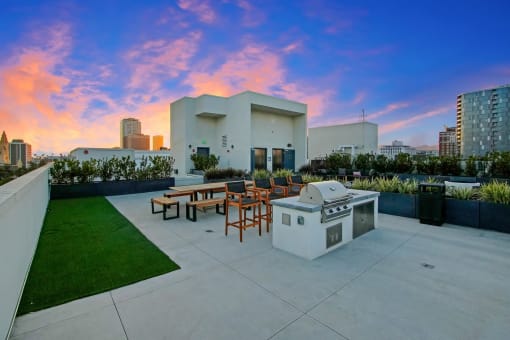 a patio with a grill and a city skyline in the background