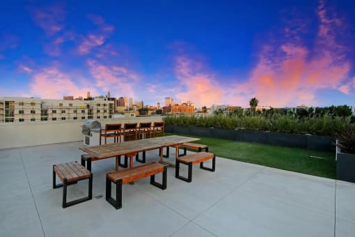 a picnic table on a patio with a city skyline in the background
