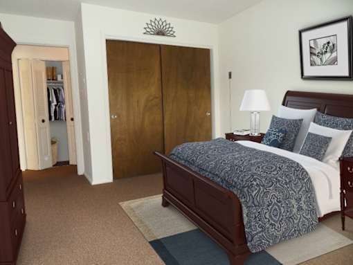 A bedroom with a bed, nightstand, and wardrobe.