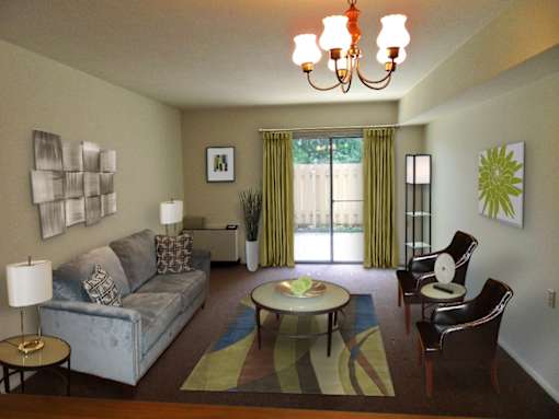 A living room with a grey couch, a coffee table, and a chandelier.