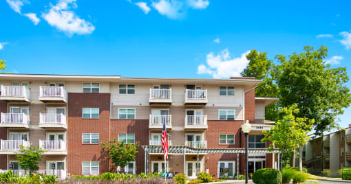 Exterior view of the apartment building at Arden Woods, showcasing well-maintained landscaping, and inviting entrances.