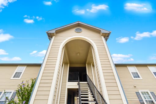 Exterior view of an apartment building with a staircase leading to the entrance at The Reserve at Chandlers Glen.