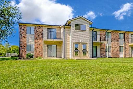 Exterior view of an apartment building at Thompson Village, showcasing balconies and patios.