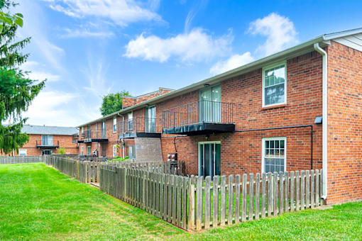 Exterior of an apartment building at Mount Vernon, featuring balconies and patios, surrounded by landscaped greenery.