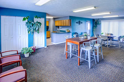 Clubhouse at Woodland Crossing, featuring a spacious communal area with seating, large windows, and a kitchen, ideal for social gatherings and events.
