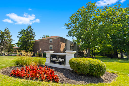 Monument sign for Carriage House Glendale Apartments, displayed in front of the property with landscaped surroundings.