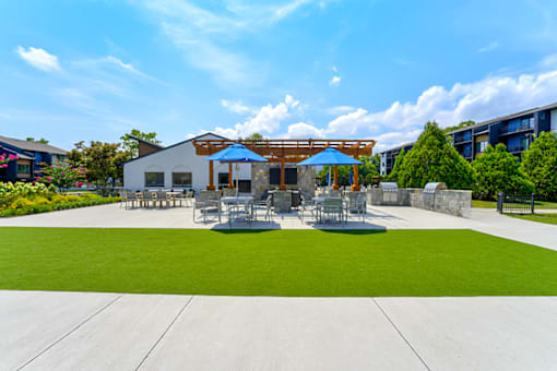 Outdoor seating and grills at Woods of Fairfax, providing residents with comfortable spaces for dining and relaxation.