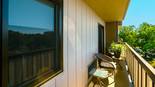 Balcony of a one-bedroom apartment at Village Square Apartments with a view of the surrounding area.