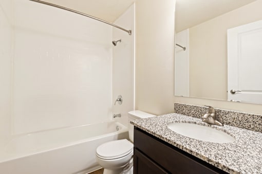 Bathroom with a sink, toilet and tub in a 1-bed, 1-bath apartment at Bradford Lake Apartments.