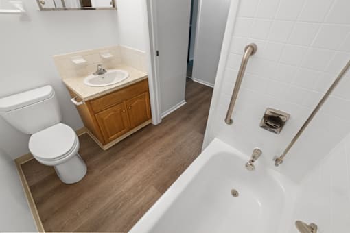 Bathroom in a 1-bed, 1-bath apartment at Carriage House Glendale, featuring a sink, toilet, and tub.