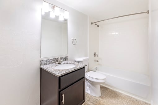 Bathroom with a sink, toilet, and bathtub in a 2-bed, 1-bath apartment at Cambridge Square Apartments in Lauderdale Lakes.