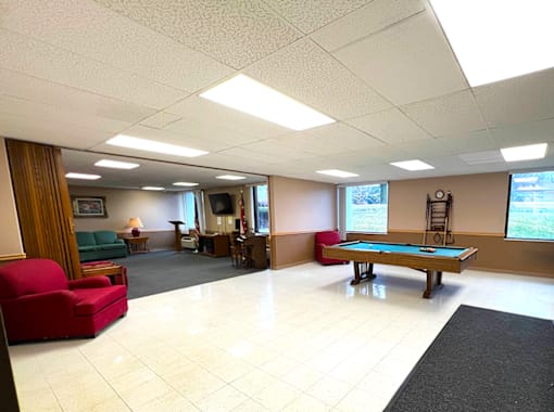 A spacious room with a pool table  at Kentwood Square Apartments.