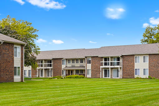 Exterior view of Greenbriar Apartments, featuring a well-maintained landscaping, balconies, and patios.