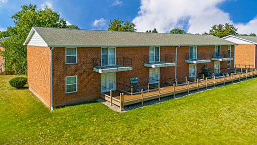 Building exterior at Cambridge Square Apartments in Flint, featuring balconies and patios with well-maintained landscaping.