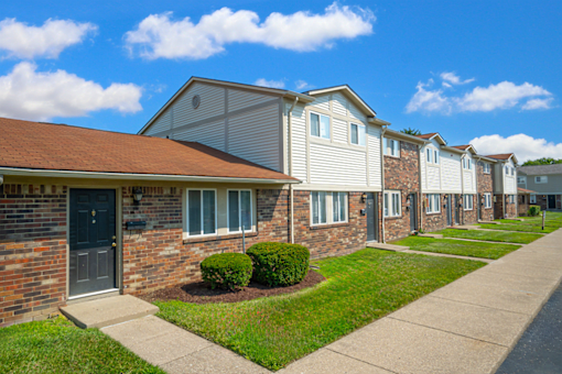 Exterior view of a building at Colonial Village Apartments, showcasing well-maintained landscaping and a classic design.