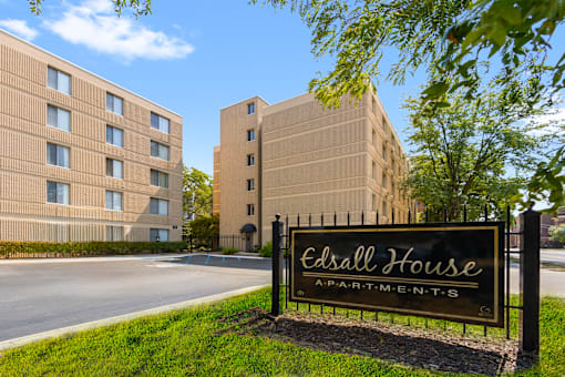Exterior view of Edsall House in Fort Wayne, featuring a monument sign in front of the apartment complex and the building in the background.