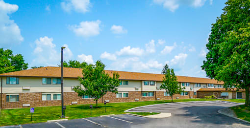 Exterior view of a building at Wesley Park Apartments with a parking lot in front.