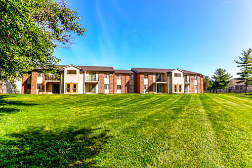 Exterior of a building at Thompson Village Apartments, showcasing a well-maintained facade and surrounding landscaping.