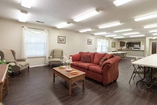 A living room with a red couch and a wooden coffee table.