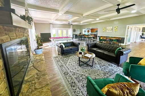 Interior of the clubhouse at Woodbridge Apartments in Bloomington, featuring furniture, pool table, and seating areas.