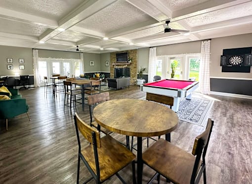 Interior of the clubhouse at Woodbridge Apartments in Bloomington, featuring furniture, pool table, and seating areas.