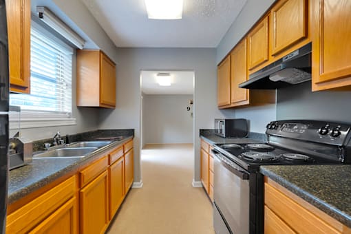Clubhouse kitchen at Valley Ridge Apartments with kitchen appliances, countertops, and a spacious layout for community events.