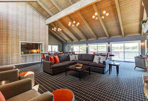 Clubhouse at Somerset Lakes Apartments, featuring a large open living room with a fireplace and a balcony for relaxation.