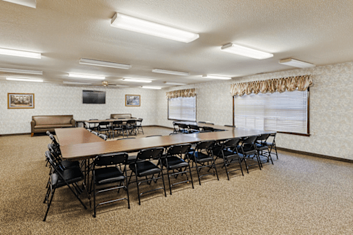 Community clubhouse at Jamestown Apartments in Seymour, Indiana, with a long table and chairs for social gatherings.