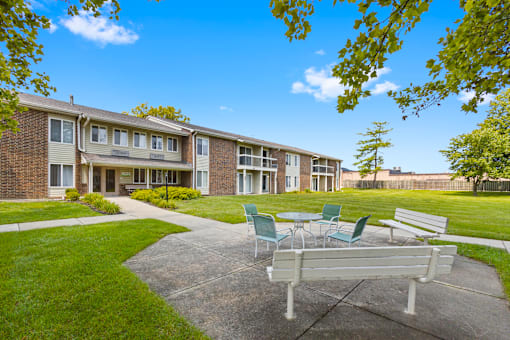 Community patio at Greenbriar Apartments with seating, offering a pleasant outdoor area for residents to gather and enjoy.