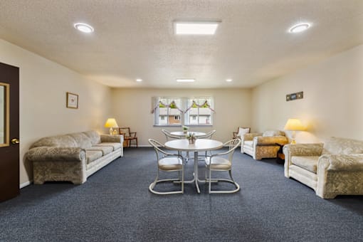 Community room with seating and tables at Blueridge Terrace Apartments.