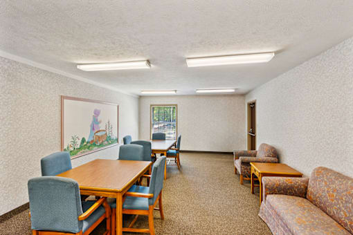 Community room with table, chairs, and bright lighting at Fairington Apartments in South Bend.