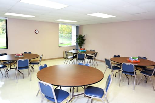 Community room with tables and chairs at Kentwood Square Apartments.