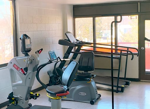 Fitness center with cardio equipment at Marshall House Apartments.