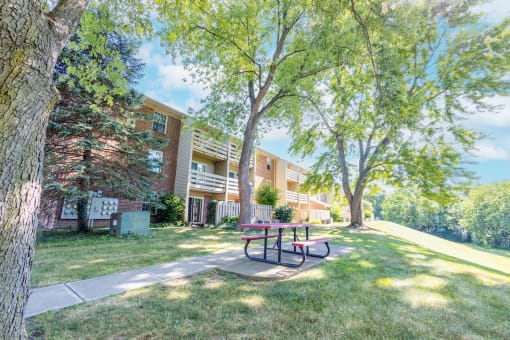 Exterior apartment building with picnic table bench seating at Cambridge Square Apartments in Beech Grove, IN