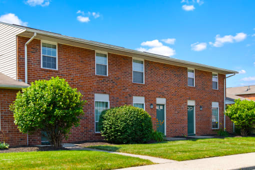 Exterior view of Windsor Park Apartments, with landscaped grounds, and welcoming entryway.