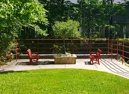 Charming garden patio at Marshall House Apartments with lush greenery and outdoor seating for relaxation.