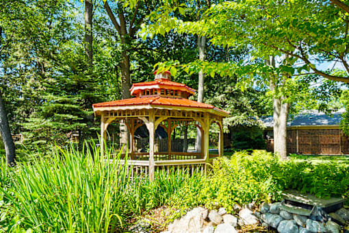 Wooden gazebo surrounded by greenery at Fairington Apartments in South Bend.
