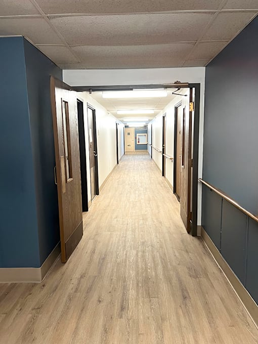 A long hallway with doors on each side at Kentwood Square Apartments.
