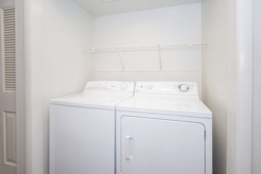 A white washing machine and dryer in a laundry room.