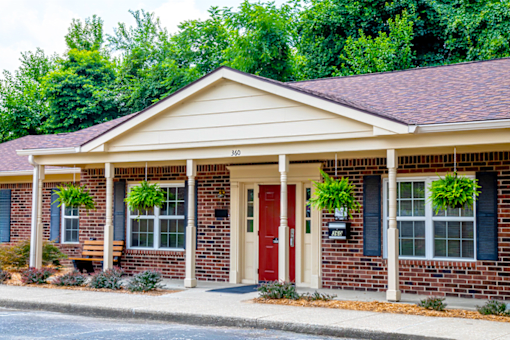 A house with a red door and a mailbox on the right side.