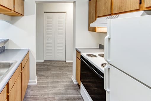 Kitchen in a 2-bedroom, 1-bath apartment at Woodland Crossing, featuring kitchen appliances, wood cabinetry, and counter space.