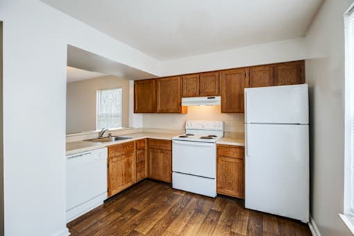 Kitchen in a 2- or 3-bedroom townhome at Hampton Place Apartments, featuring appliances, counter space, and cabinets.