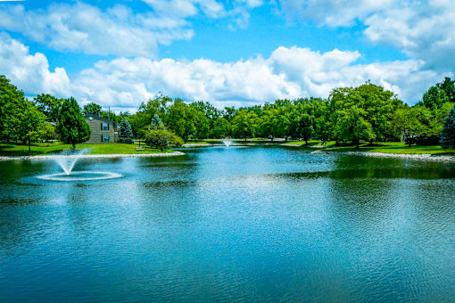 Large pond at Jamestown Valparaiso, surrounded by lush greenery and trees.