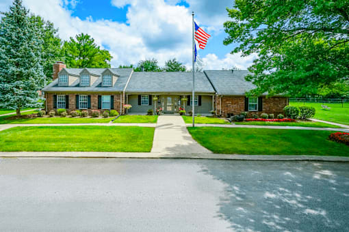 Exterior view of the leasing office at Jamestown Valparaiso, featuring a welcoming entrance, large windows, and landscaped greenery.