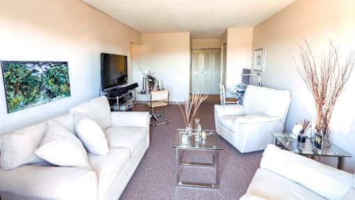 Living room with furniture and a flat screen TV at Village Square Apartments.