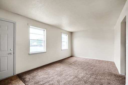 Living room in a 3-bed, 1-bath townhome at Valley Ridge Apartments, featuring a spacious layout and large windows for natural light.
