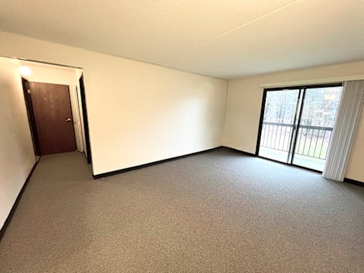 Living room with patio access in a one-bedroom, one-bathroom apartment at Kentwood Square Apartments.