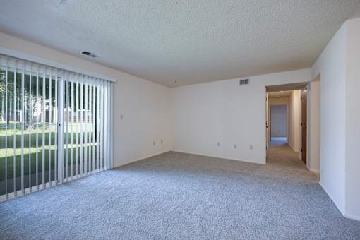 Living room with sliding doors leading to  a patio in a 3 Bedroom Apartment at Regency Park Apartments
