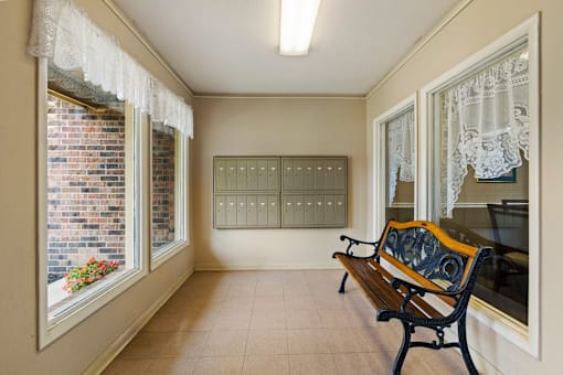 Mailroom at Fairington Apartments in Lafayette, featuring organized mailboxes along with a bench for comfortable seating.