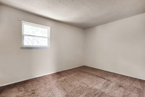 Master bedroom in a 3-bed, 1-bath townhome at Valley Ridge Apartments, featuring a spacious layout and large windows for natural light.